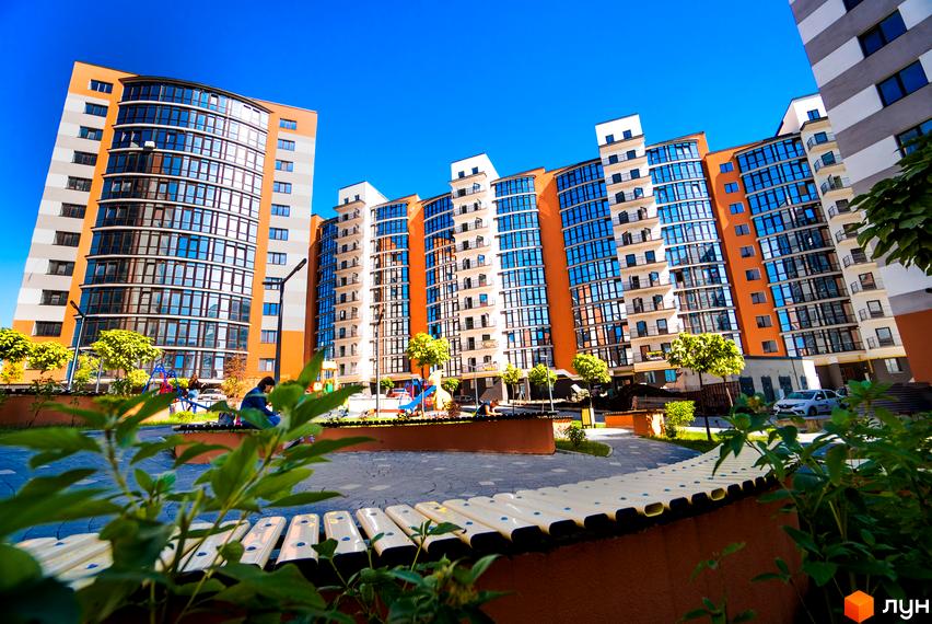 Зображення фасаду та прибудинкової території Житлового комплексу Містечко Соборне. Вигляд на дитячий майданчик та ландшафтний дизайн.