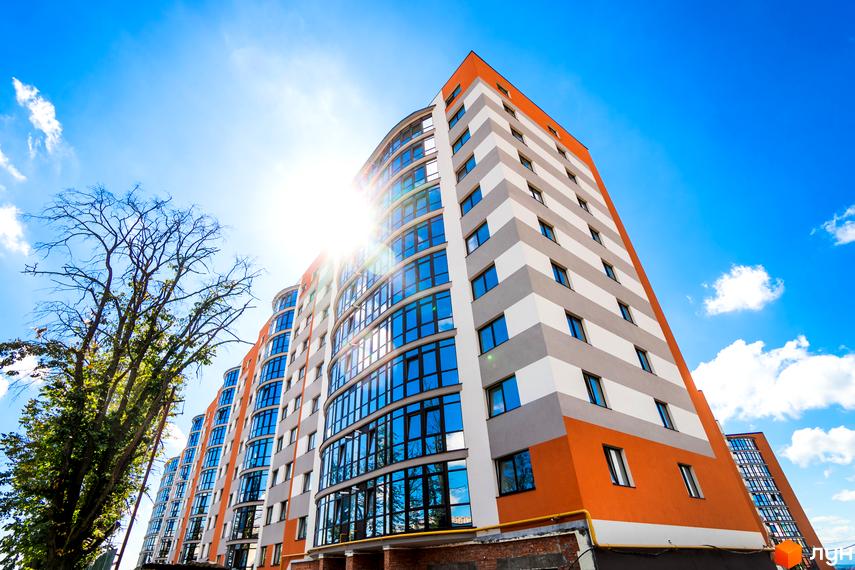 Зображення багатоповерхового будинку в Житловому комплексі Містечко Соборне на фоні блакитного неба. Вигляд фасаду та вікон.