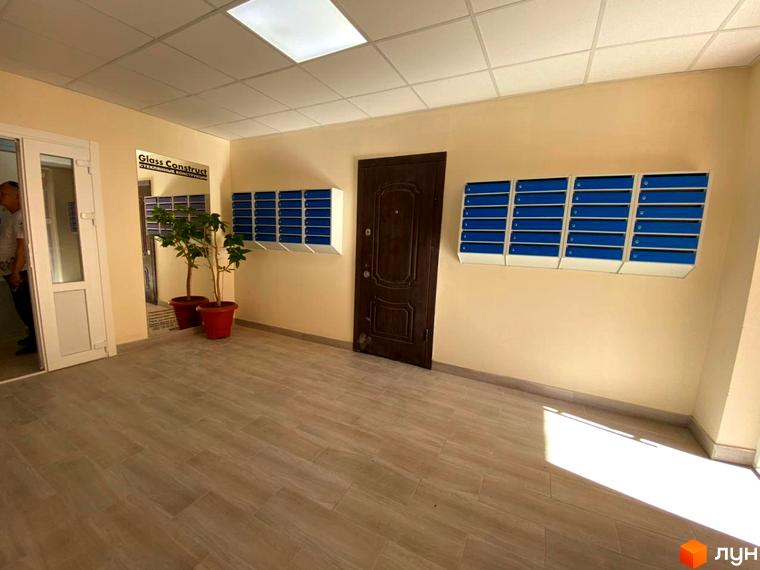 Житловий комплекс Металіст: сучасний під'їзд з поштовими скриньками та дверима. Елегантний дизайн інтер'єру з рослинами та підлогою під дерево.