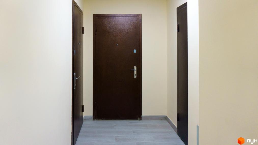 Житловий комплекс Металіст: простір для життя. На фото представлено коридор з вхідними дверима до квартир, що свідчить про функціональність помешкань.