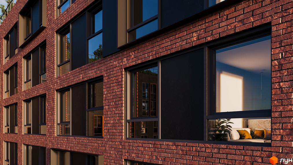Зовнішній вигляд новобудови Urban One Sumskaya з червоної цегли та великими вікнами. Вікна відображають внутрішній інтер'єр з диваном та подушками.
