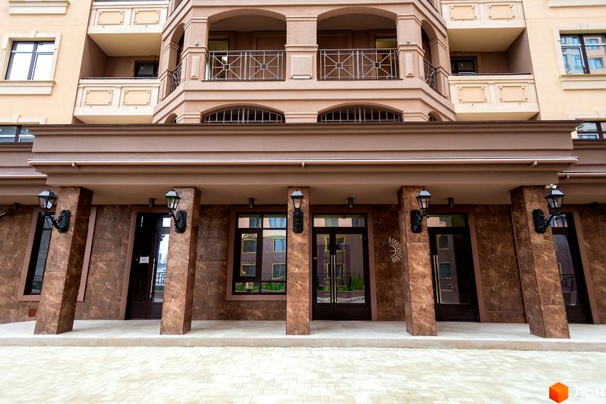 Фасад житлового комплексу Елегія Парк з колонами та дверима. Зовнішній вигляд будинку з балконами та вікнами.