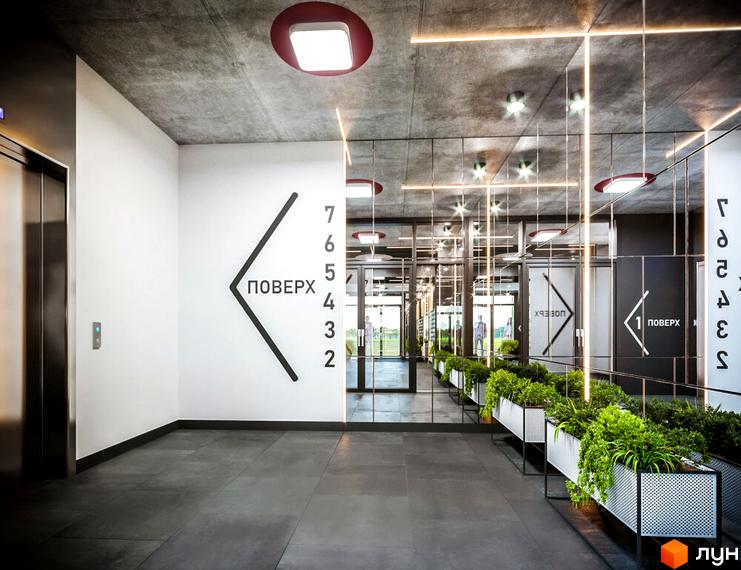Інтер'єр лобі Житлового комплексу HYGGE з ліфтом, дзеркальною стіною, зеленими рослинами та вказівниками поверхів.