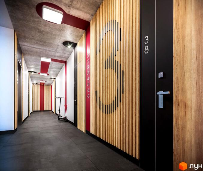 Інтер'єр коридору Житлового комплексу HYGGE з бетонною стелею, дерев'яними ламелями та червоними елементами декору. Видно двері квартир та номер 38.