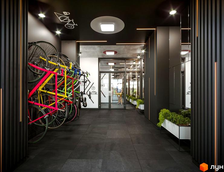 Вхідна група Житлового комплексу HYGGE з велопарковкою. Оформлення інтер'єру з темними панелями та озелененням.