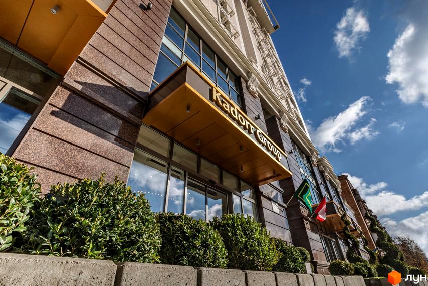 Житловий комплекс Тридцять восьма перлина з фасадом з вікнами та прибудинковою територією з зеленими насадженнями.