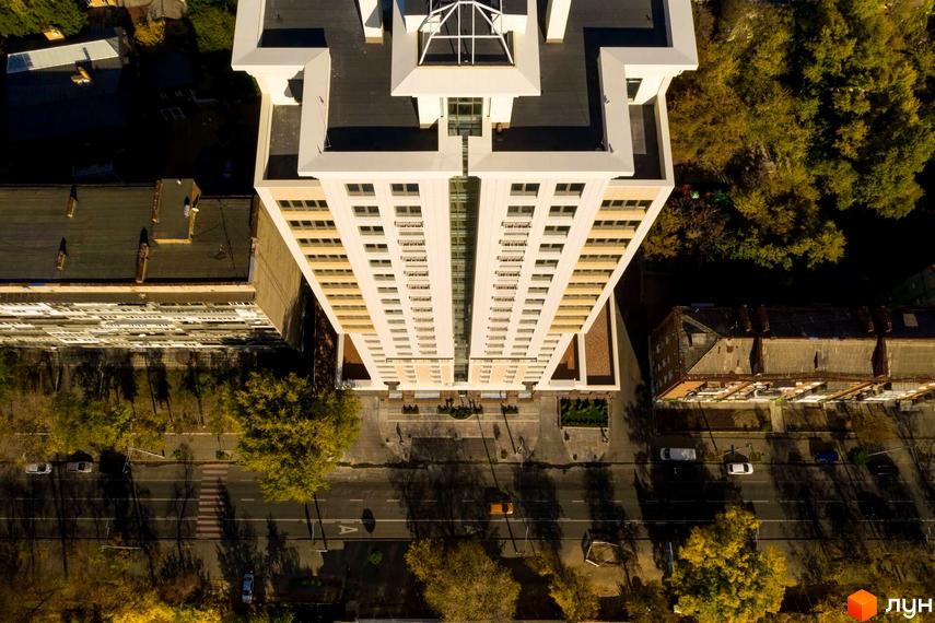 Вид на житловий комплекс Тридцять восьма перлина з висоти. Прибудинкова територія з зеленими насадженнями та асфальтованими доріжками.