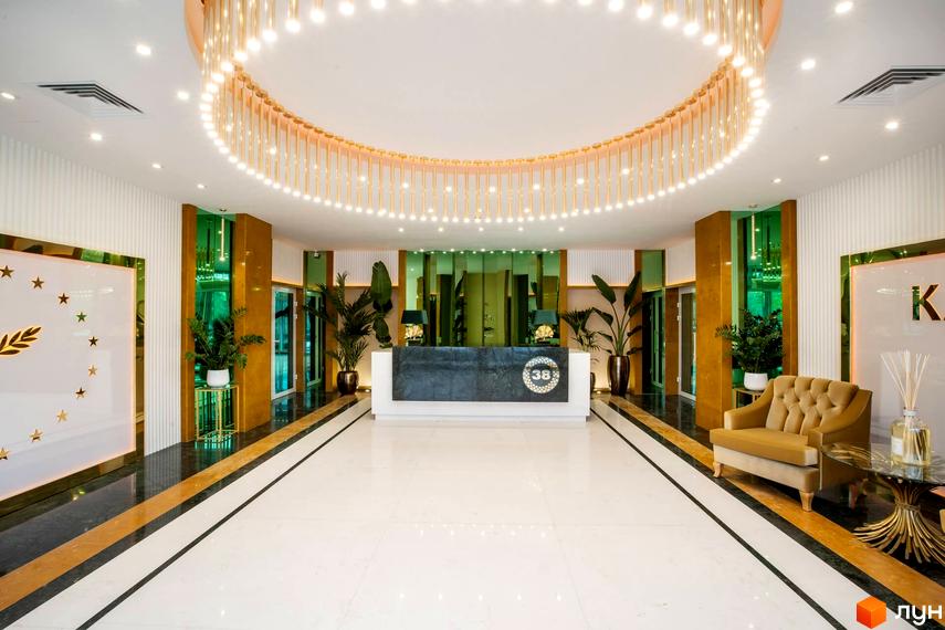 Сучасний інтер'єр рецепції житлового комплексу Тридцять восьма перлина з елегантним освітленням та зеленими рослинами.