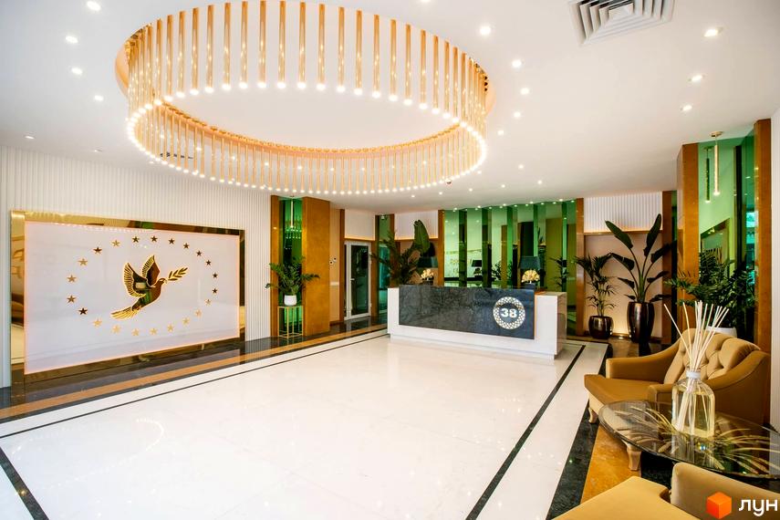Сучасний хол житлового комплексу Тридцять восьма перлина з елегантним дизайном та зеленими рослинами.