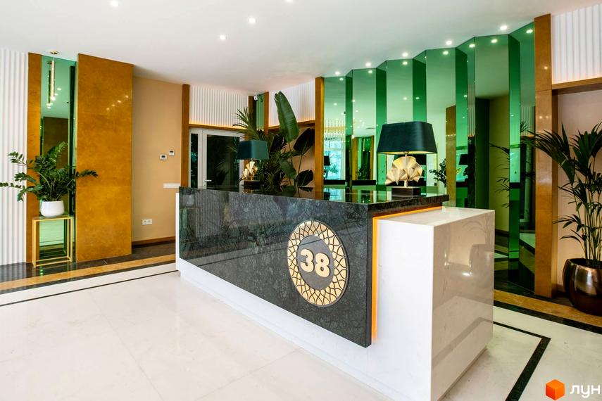 Сучасний рецепційний зал житлового комплексу Тридцять восьма перлина з елегантним оформленням та рослинами.