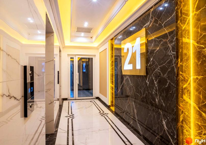Сучасний коридор житлового комплексу Тридцять восьма перлина з мармуровими стінами та стильним освітленням.