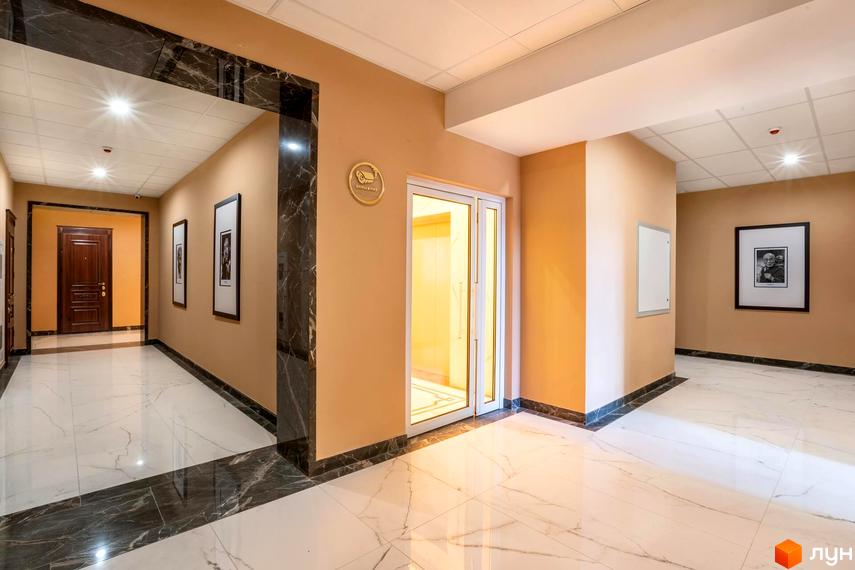 Сучасний коридор житлового комплексу Тридцять восьма перлина з мармуровою підлогою та декоративними елементами. Яскраве освітлення та стильні картини на стінах.