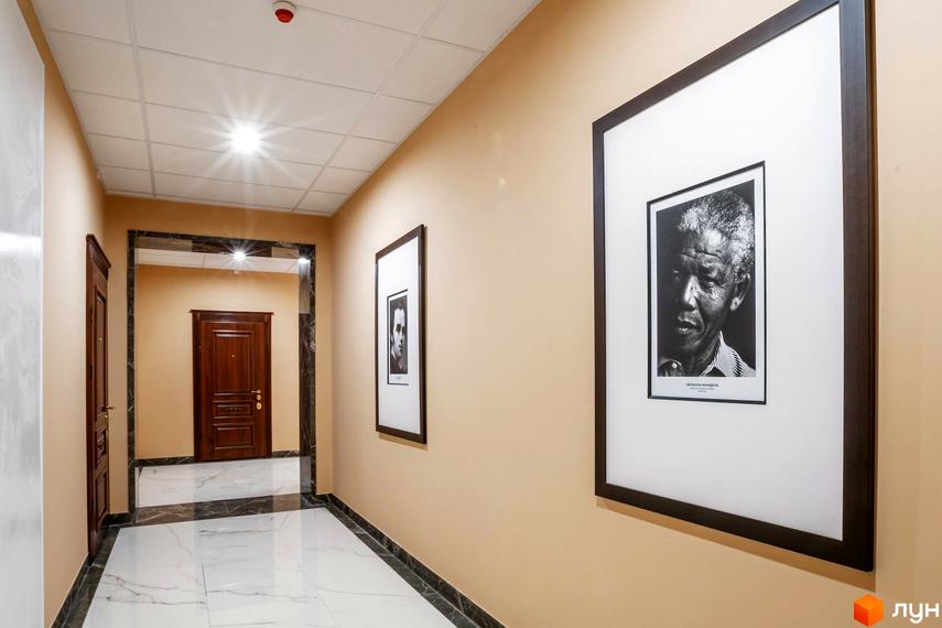 Сучасний коридор житлового комплексу Тридцять восьма перлина з дверима та фотозображеннями на стінах.
