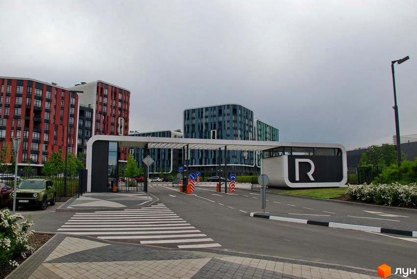 Житловий комплекс Respublika з багатоповерховими будинками червоного та синього кольорів. Вхідна група облаштована пішохідним переходом, дорогами та зеленою зоною.