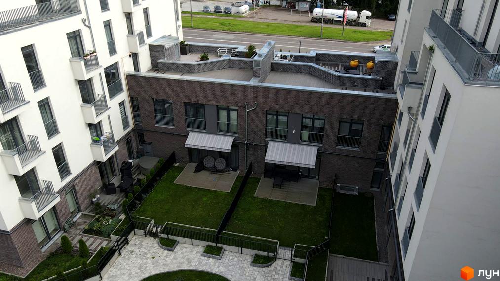 Зовнішній вигляд новобудови ЖК Villa Magnolia з балконами та прибудинковою територією з газоном та доріжками. Огляд житлового комплексу.