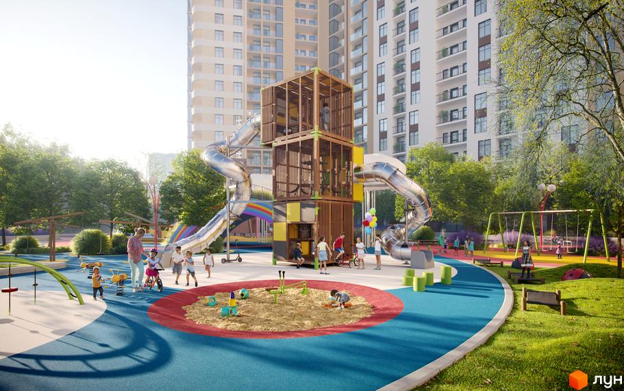 Дитячий майданчик біля житлового комплексу KADORR City з високими будинками та зеленими деревами. На майданчику є гірки, гойдалки та пісочниця.