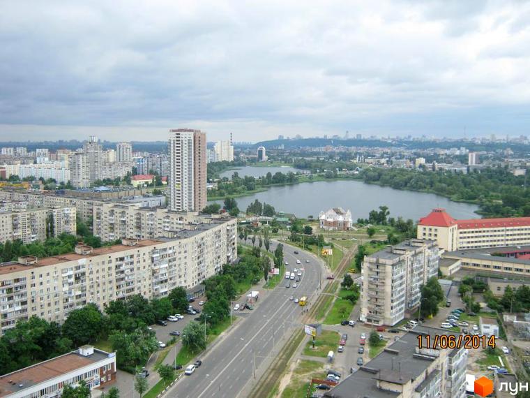 Вид на житловий комплекс Гранд з висоти пташиного польоту. На зображенні видно багатоповерхові будинки, зелені насадження та дорогу з автомобілями.