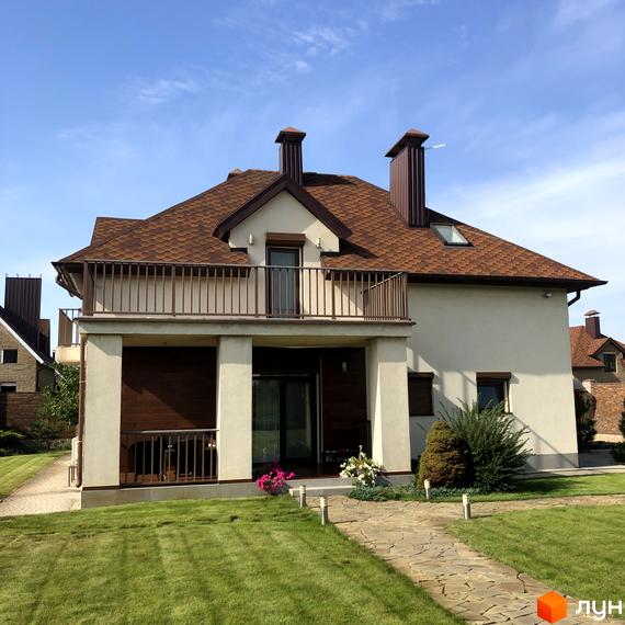 Котеджне містечко Барвіта: двоповерховий будинок з коричневим дахом та балконом, доглянута зелена територія з доріжкою.