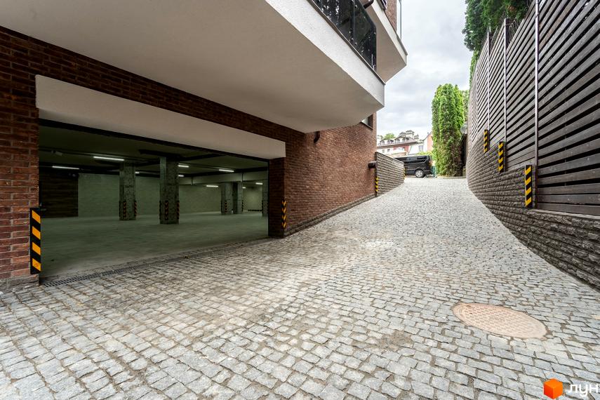 В'їзд у підземний паркінг житлового комплексу на вул. Ломаківська (Мічуріна), 19б. Бруківка веде до входу в паркінг та до будинку.