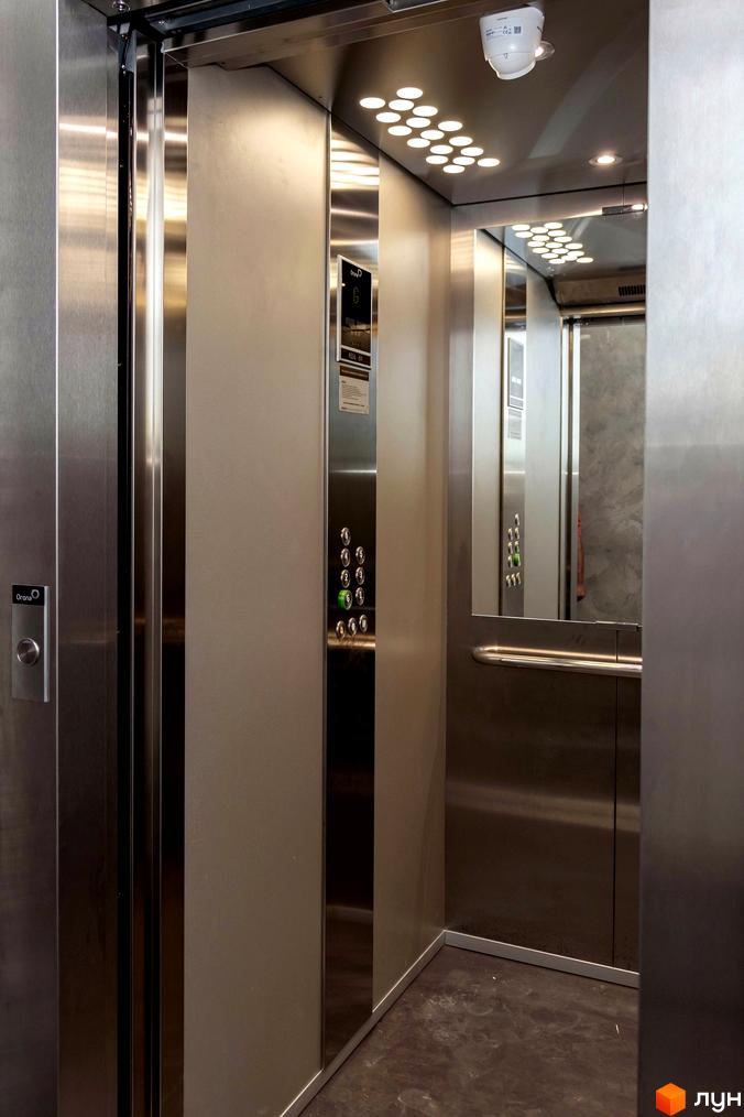 Інтер'єр ліфта в новобудові на вул. Ломаківська (Мічуріна), 19б. Металеві стіни та панель керування з кнопками.