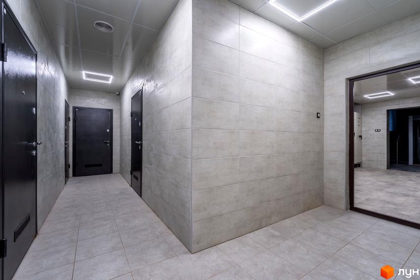 Коридор з сірими стінами та дверима в житловому комплексі на вул. Ломаківська (Мічуріна), 19б. Якісне оздоблення стін та підлоги.