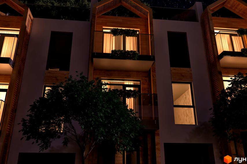 Житловий комплекс Royal Estate. Нічний вид на фасади будинків з дерев'яними елементами, балконами та підсвіченими вікнами. Поруч росте дерево.