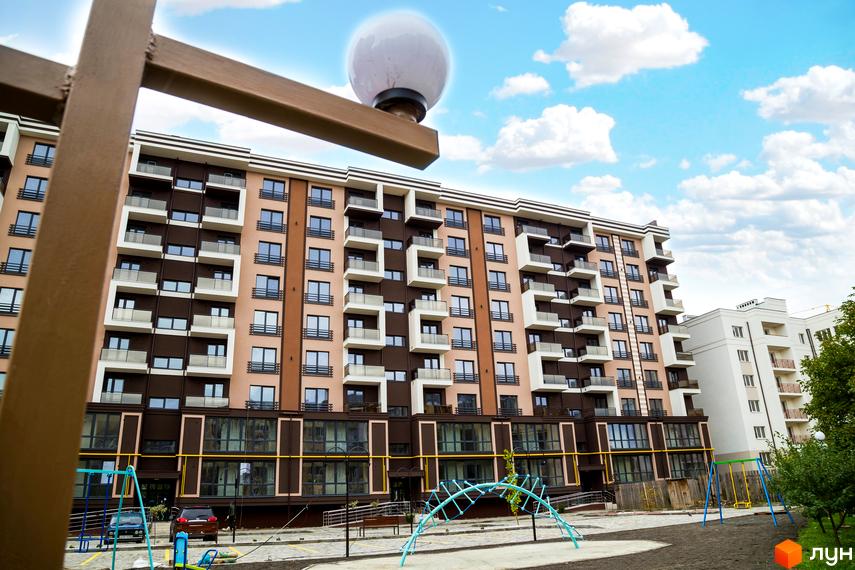 Зовнішній вигляд Житлового комплексу Modern. Багатоповерховий будинок з балконами та дитячим майданчиком на прибудинковій території.