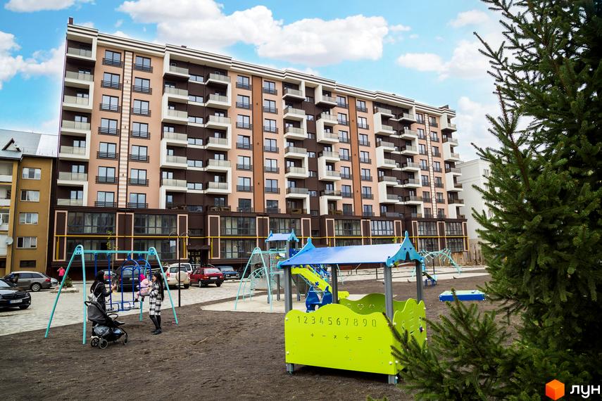Зображення фасаду та дитячого майданчика Житлового комплексу Modern. Багатоповерховий будинок з великою ігровою зоною для дітей.