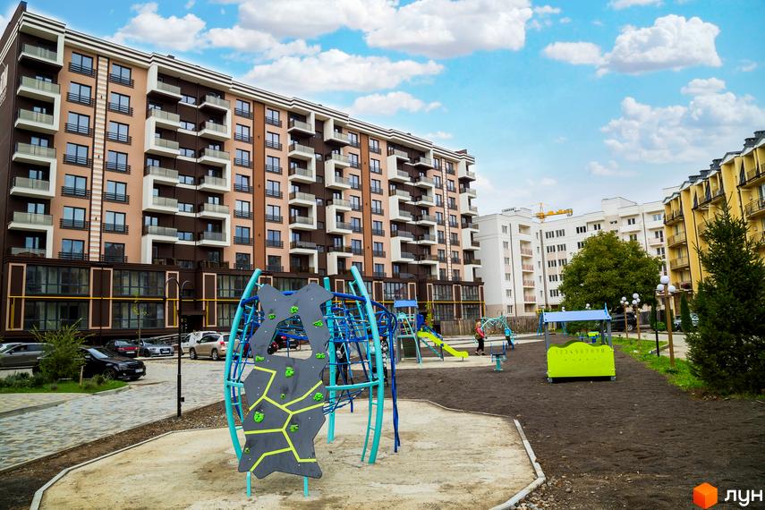 Зовнішній вигляд багатоквартирного будинку в Житловому комплексі Modern. На території розташований дитячий майданчик.