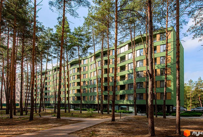 Зображення житлового комплексу Park Town з зеленим фасадом та великими вікнами. На передньому плані видно дерева та доріжки для прогулянок.
