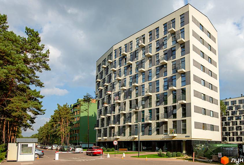 Висотна новобудова ЖК Park Town з балконами та великими вікнами. На території комплексу є парковка, зелені насадження та дорога з автомобілями.