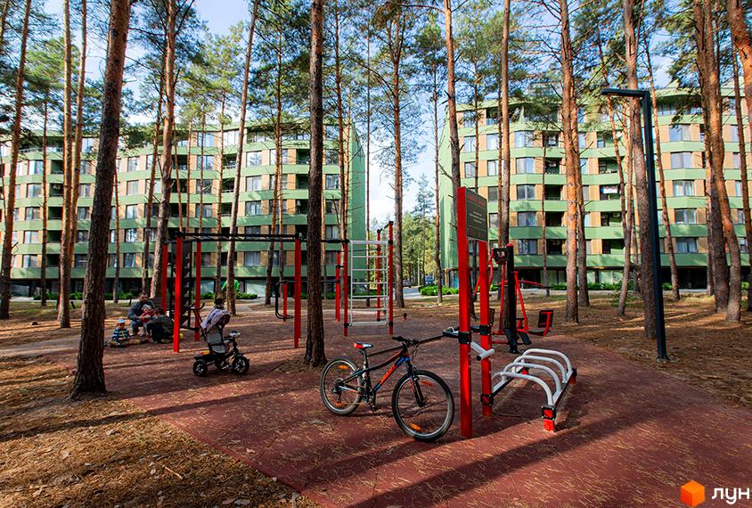 Житловий комплекс Park Town з зеленими фасадами розташований серед дерев. На території є спортивний майданчик та дитячий транспорт.