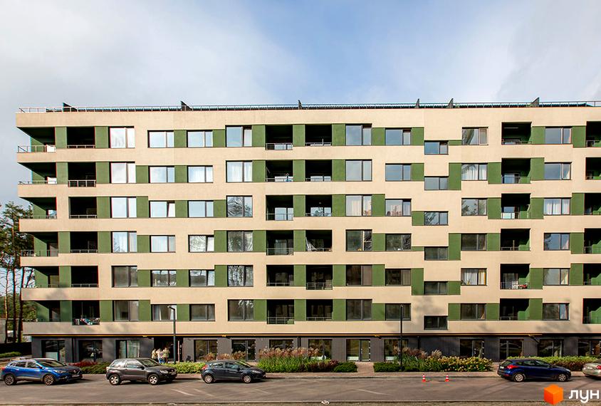 Багатоповерховий будинок ЖК Park Town з великою кількістю вікон та зеленими вставками на фасаді. Перед будинком розташована парковка з автомобілями та зелені насадження.