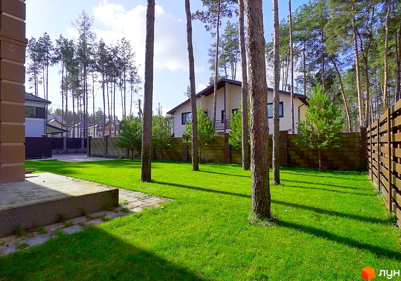 Котеджне містечко КМ Сонячний 2. Зовнішній вигляд будинку з великими вікнами, прибудинкова територія з доглянутим газоном та деревами.