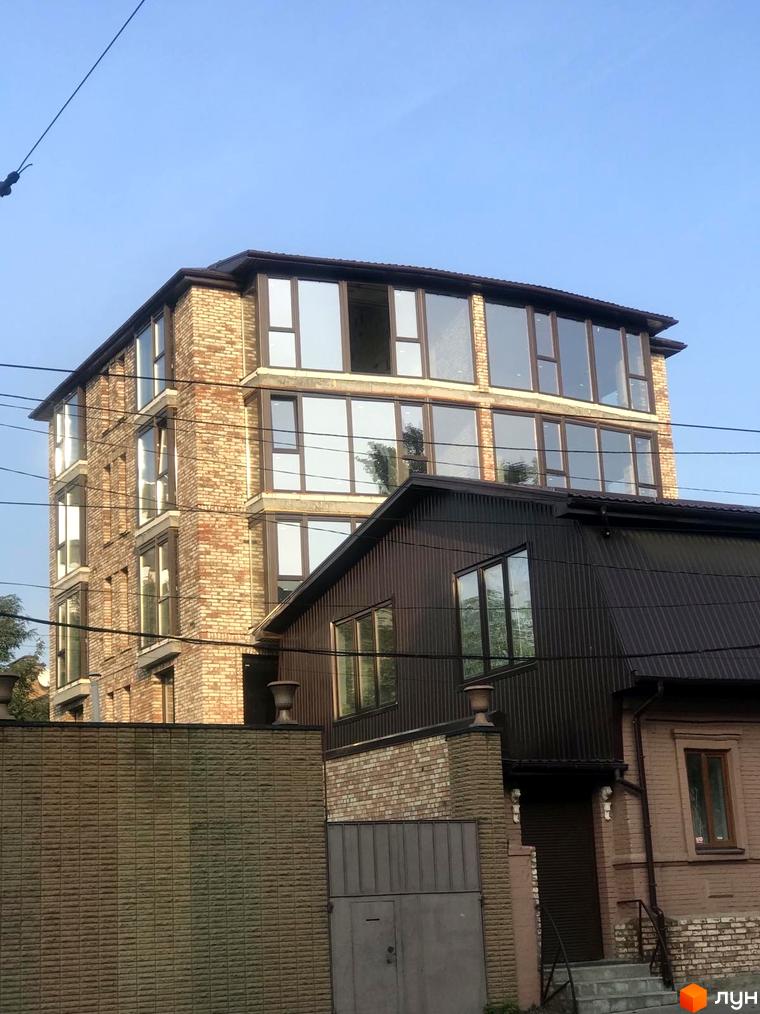 Клубний будинок Чернишевського 20 з цегляним фасадом та великими вікнами. Поруч розташована прибудинкова територія з парканом та воротами.