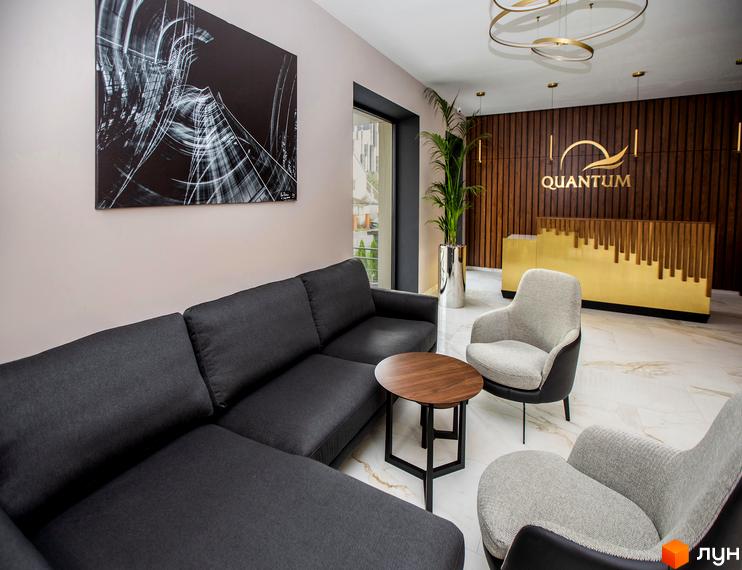 Інтер'єр зони відпочинку Житлового комплексу Baltiysʹka Hall з диваном, кріслами та журнальним столиком. На стіні висить картина.