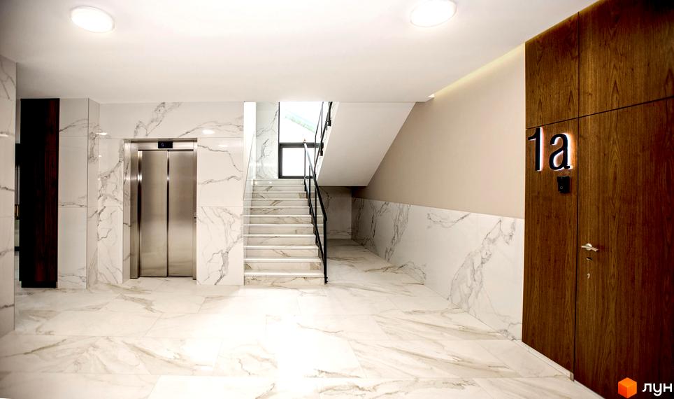 Інтер'єрний хол житлового комплексу Baltiysʹka Hall з ліфтом, сходами та мармуровим оздобленням. На стіні видно номер 1а.