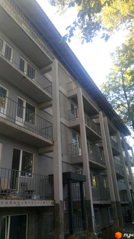 Житловий комплекс Котляревського: багатоповерхова будівля з балконами та світлими вікнами. Навколо території ростуть дерева.