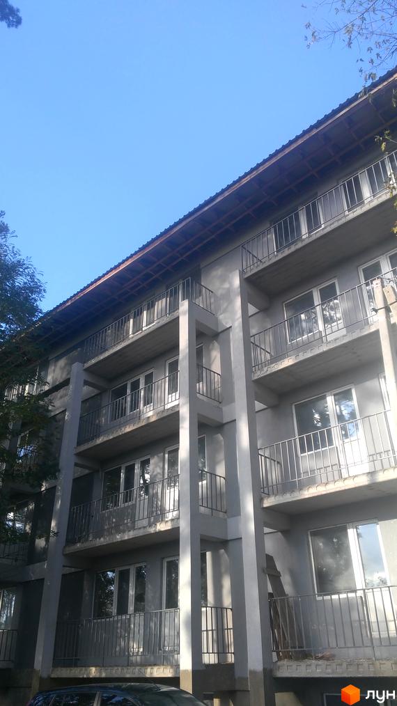 Зовнішній вигляд будинку житлового комплексу Котляревського з балконами та вікнами на тлі блакитного неба.