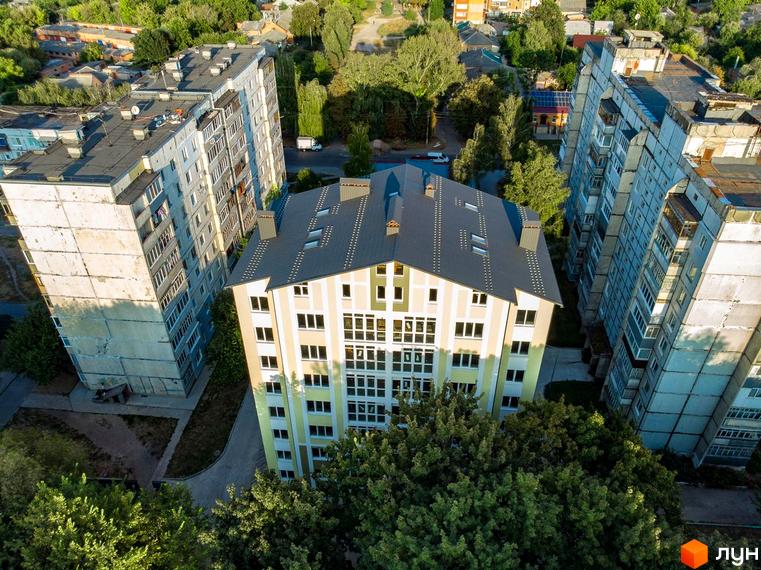 Зовнішній вигляд новобудови на вул. Гостиннодвірська, 14в, з багатоповерховими будинками та зеленою прибудинковою територією.