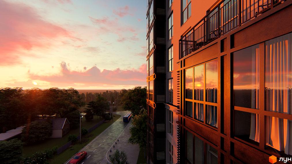 Вид на житловий комплекс Янтарний з вікна під час заходу сонця. Навколо зелені дерева та дорога з автобусом.