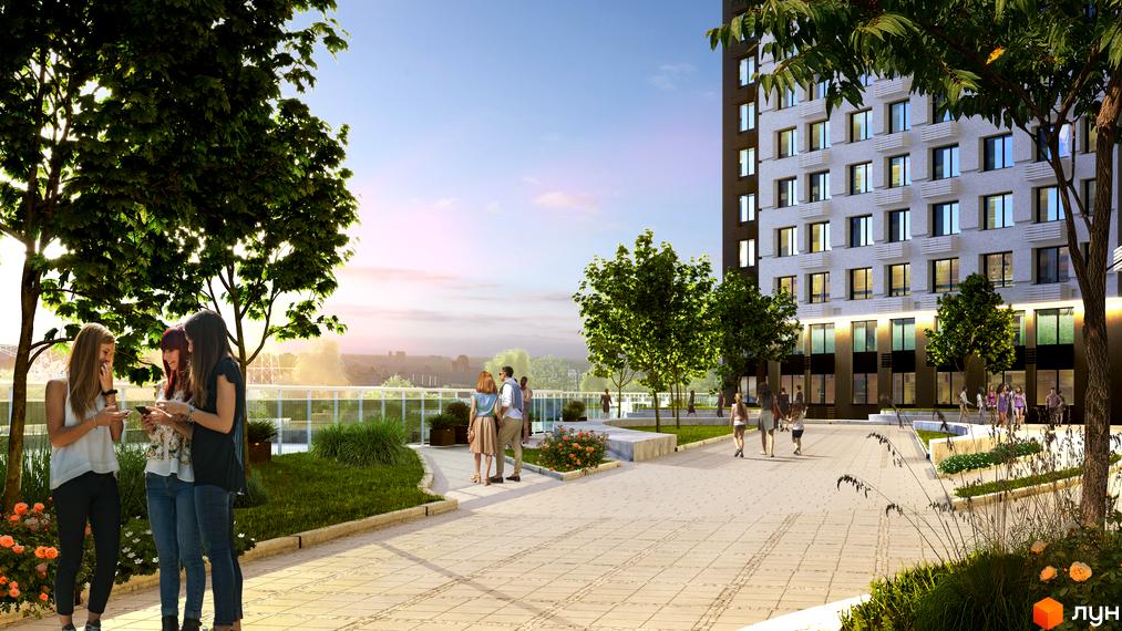 Фасад житлового комплексу POLARIS Home&Plaza зі світлими стінами та темними вікнами. Облаштована прибудинкова територія з деревами та доріжками.