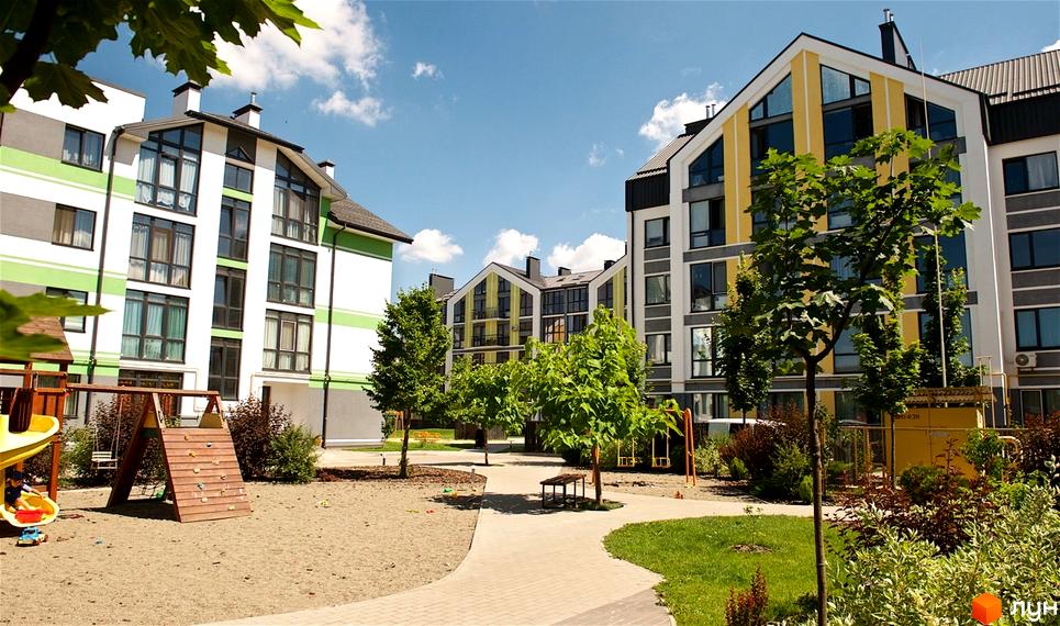 Житловий комплекс Петрівське містечко. Сучасні новобудови з яскравими фасадами та дитячим майданчиком на доглянутій прибудинковій території.