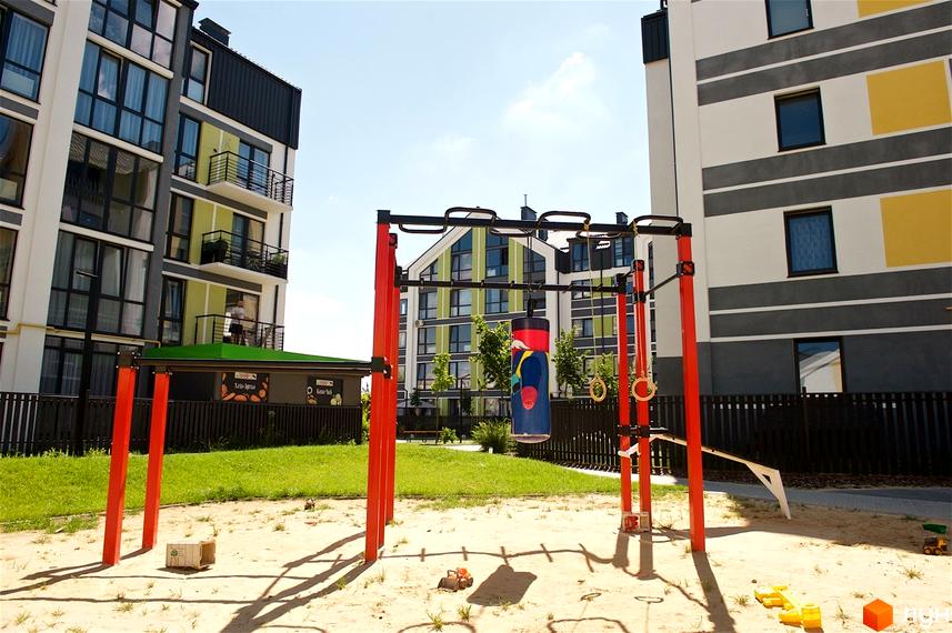 Житловий комплекс Петрівське містечко з дитячим майданчиком та зоною для тренувань. Сучасні багатоповерхові будинки з яскравими фасадами та балконами.
