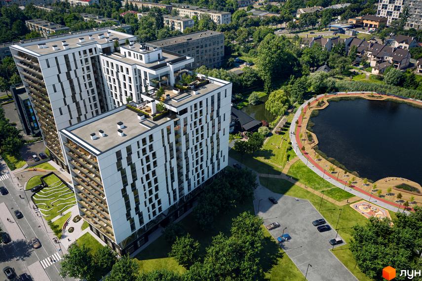 Житловий комплекс Pictorial з білими фасадами та балконами, розташований біля озера з доглянутою прибудинковою територією та місцями для відпочинку.