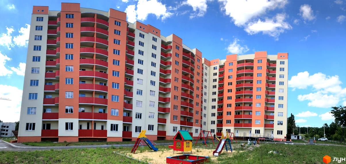 Зображення фасаду та дитячого майданчика Житлового району Подвір'я. Вигляд багатоповерхового будинку з вікнами та балконами.