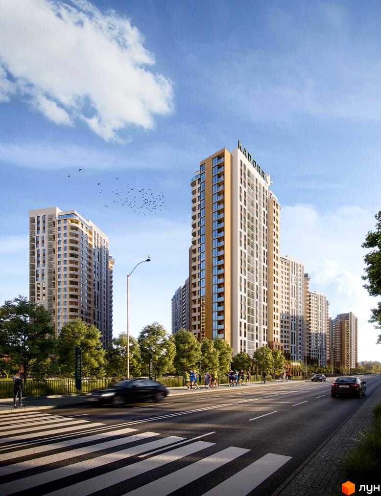 Вид на житловий комплекс KADORR City з високими будинками та зеленою прибудинковою територією. На зображенні також видно дорогу з пішохідним переходом та автомобілями.