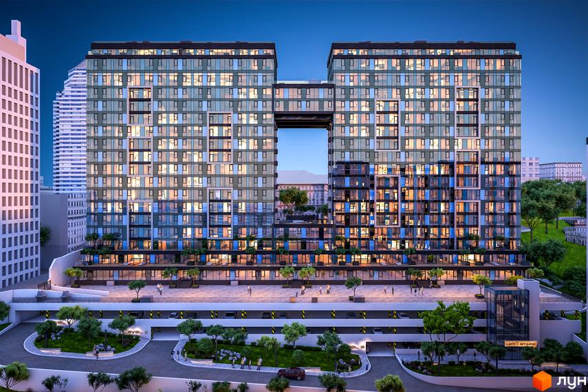 Житловий комплекс Nebo з двома вежами, з'єднаними переходами, та багатоярусною парковкою. Навколо комплексу розташовані зелені зони та дерева.