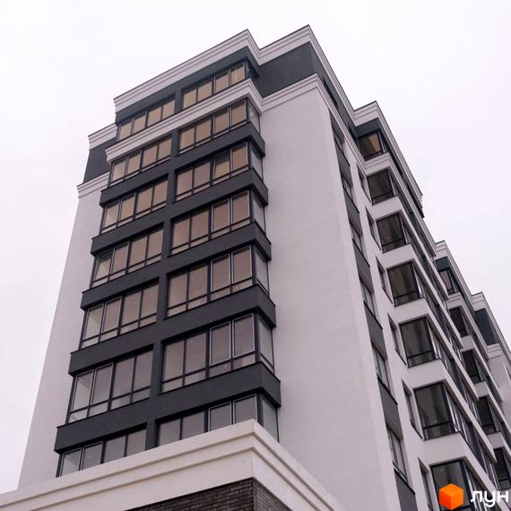 Фасад багатоповерхової Новобудови Олімп з білими стінами та темно-сірими віконними блоками.