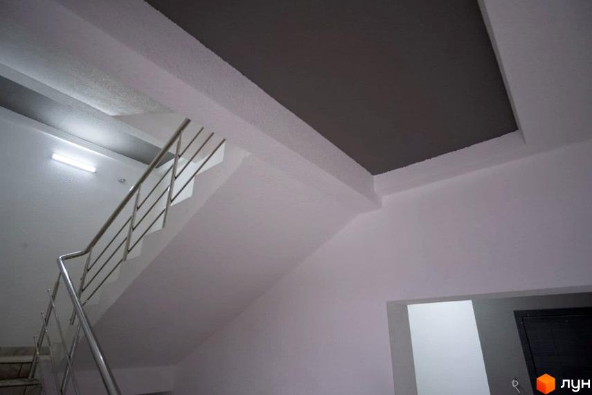 Інтер'єр Житлового комплексу Олімп: сходи з металевими поручнями, білі стіни та стеля з сірою вставкою.